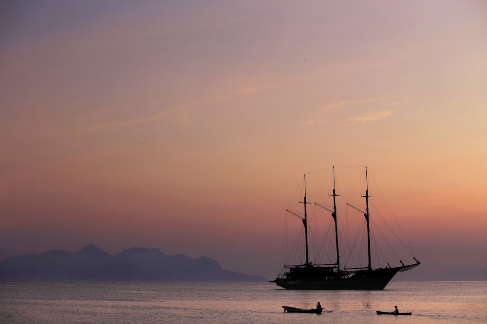 black sail boat on sea during daytime