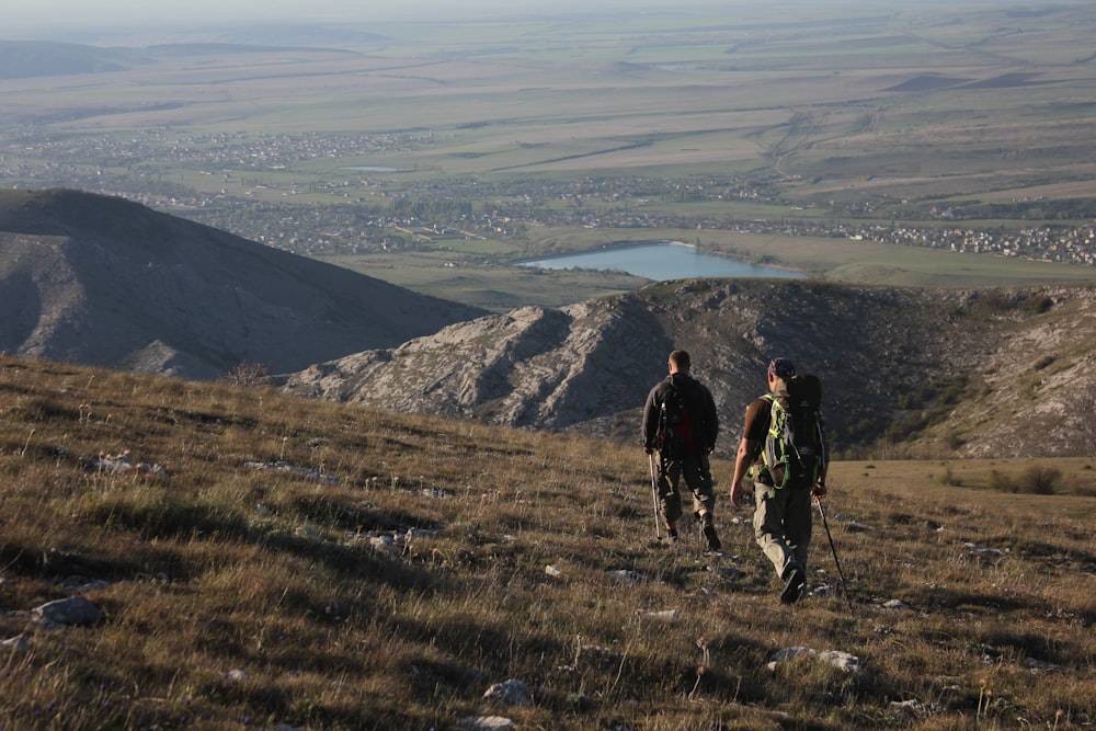 2 men hiking on mountain during daytime