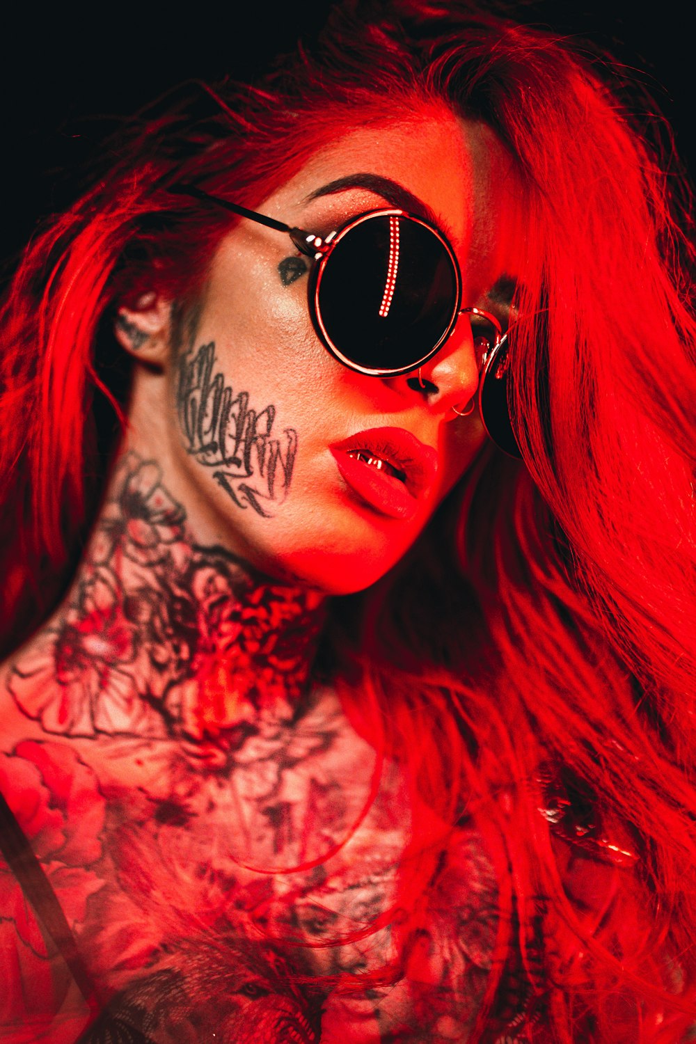 Mujer con pelo rojo con gafas de sol negras