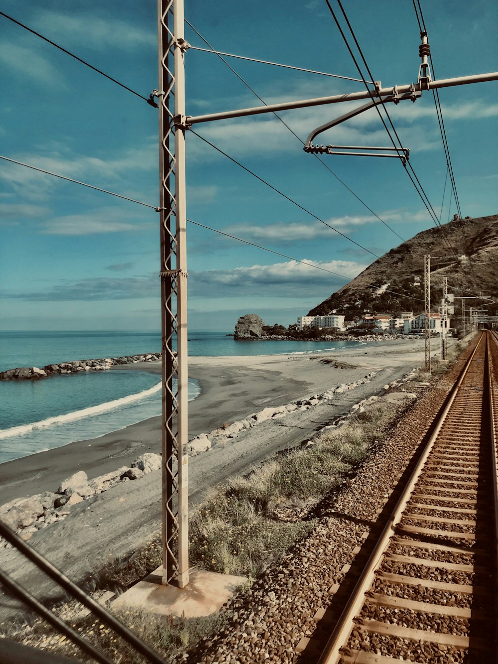 brown metal train rail near sea during daytime