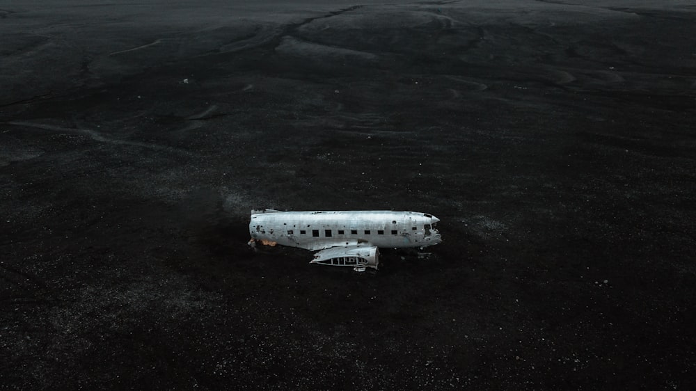 white and black airplane on black sand