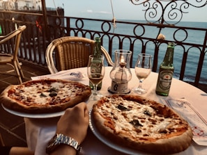 A cozy table set at Casa Roja Pizzeria with a couple sharing a pizza and drinks.
