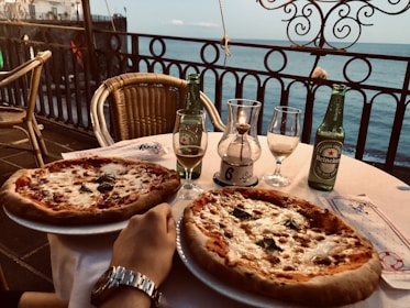 A cozy table set at Casa Roja Pizzeria with a couple sharing a pizza and drinks.