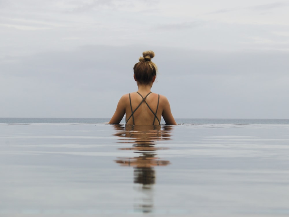 femme en bikini noir sur l’eau