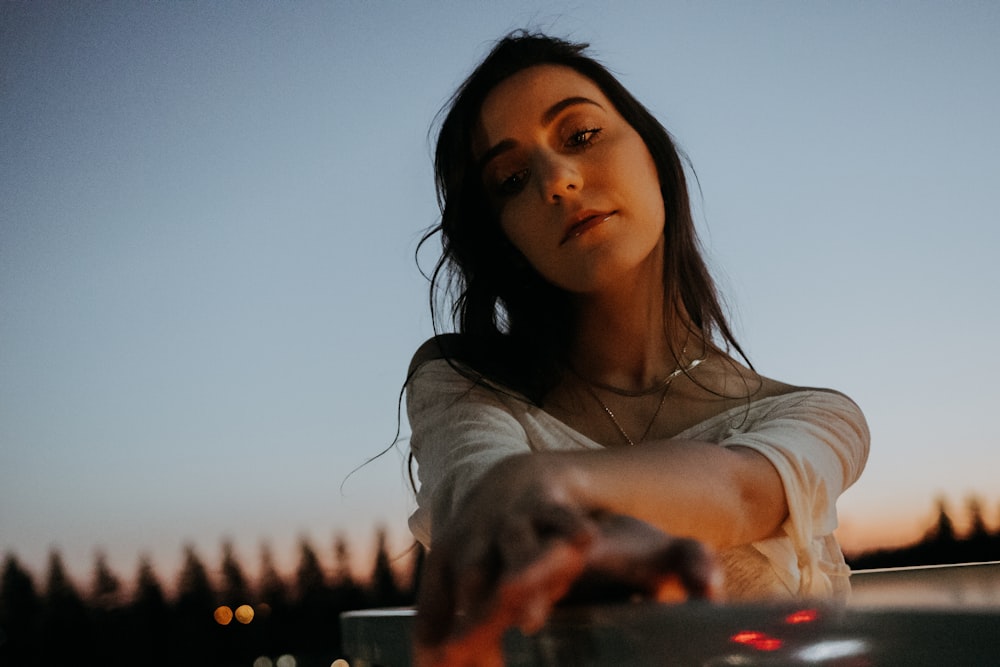 woman in white shirt holding her hair