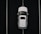 Aerial view of a white car parked in a space outlined by parallel white lines on a dark asphalt surface.