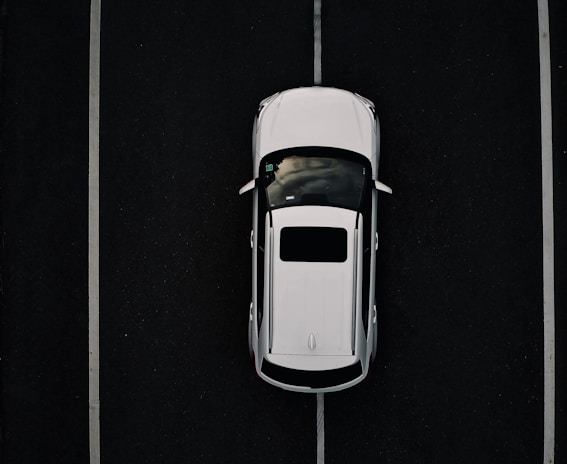 Aerial view of a well-marked parking lot with clear yellow lines on a dark asphalt surface.