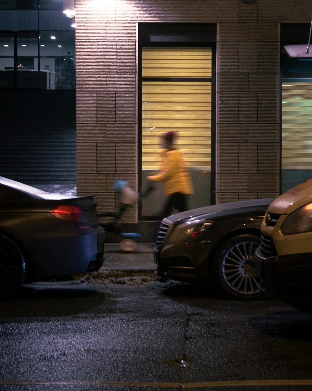 black car parked beside brown brick building