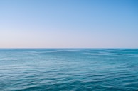 A panoramic view of a calm ocean with no visible curvature at the horizon.