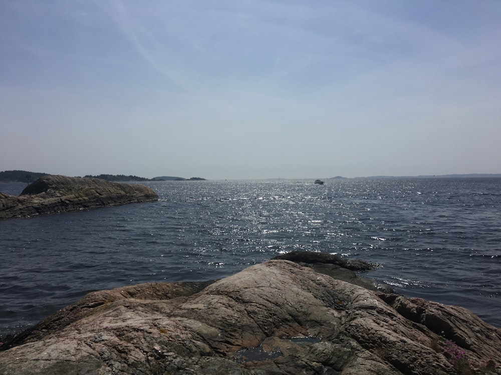 brown rock formation beside body of water during daytime