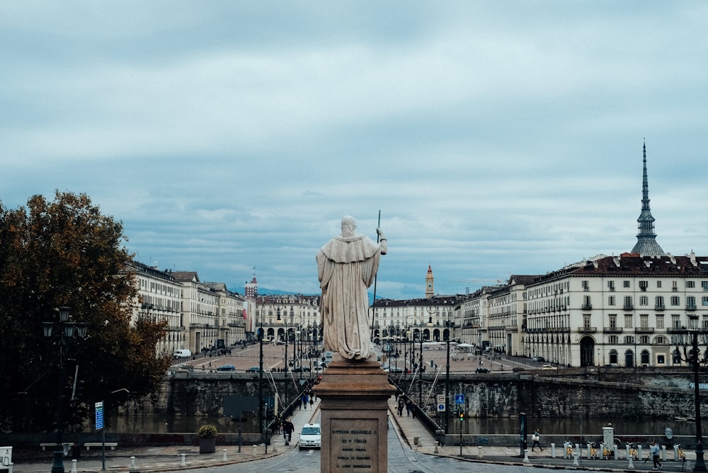 white statue of man on brown concrete stand