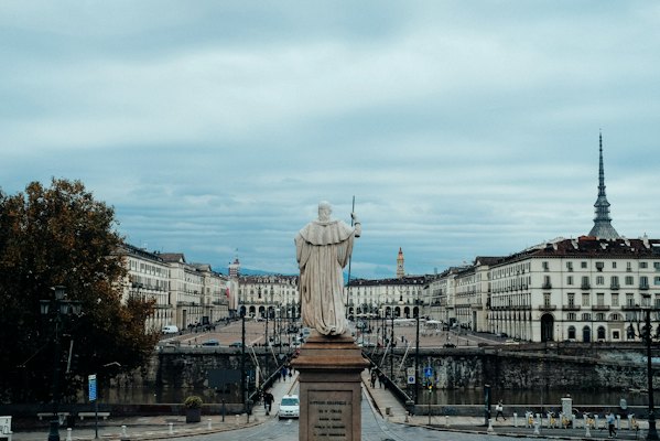 White statue of man on brown concrete stand — Turin, Italy