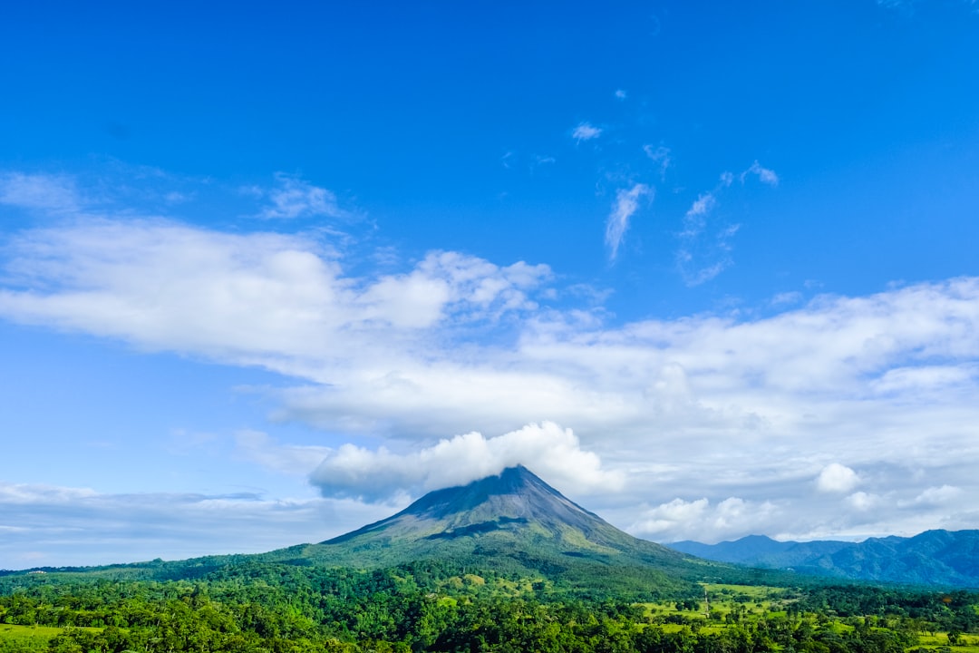 green mountain under blue sky and white clouds during daytime