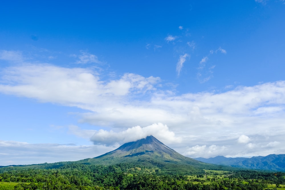 green mountain under blue sky and white clouds during daytime