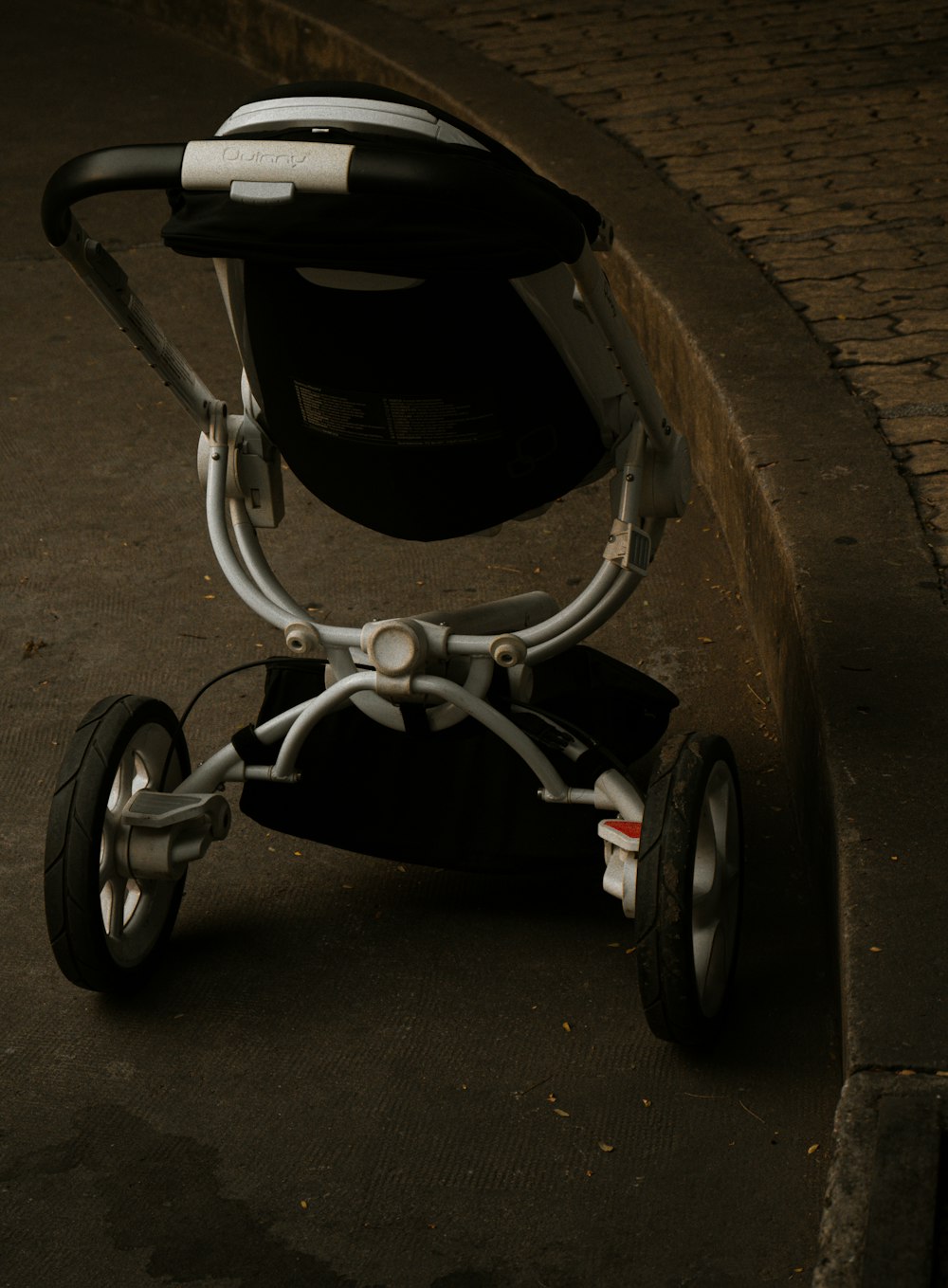 black and gray stroller on gray concrete floor