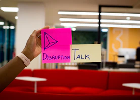 person holding pink sticky notes