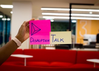 person holding pink sticky notes