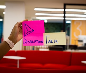 person holding pink sticky notes