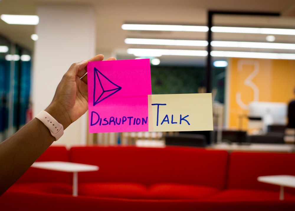 person holding pink sticky notes