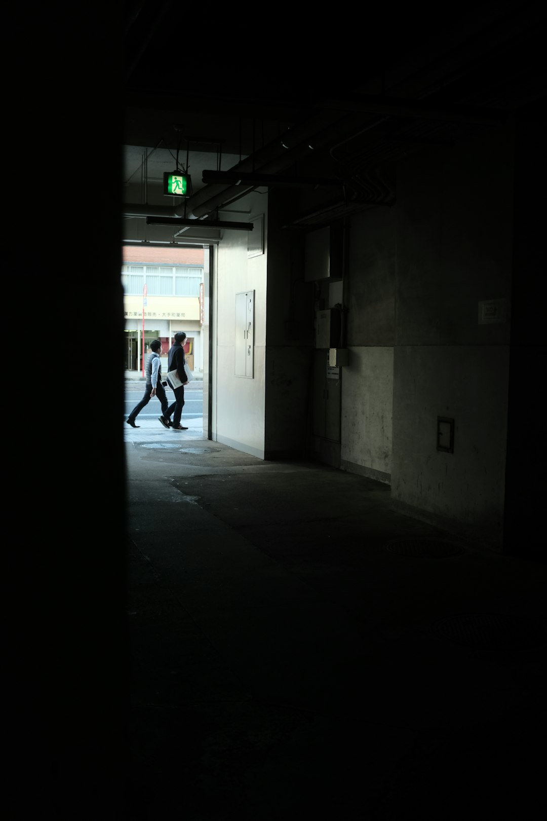 man in white shirt walking on hallway