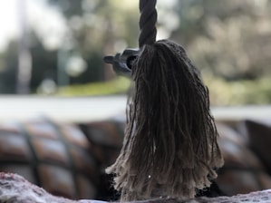 Close-up of hands carefully splicing a thick rope outdoors.