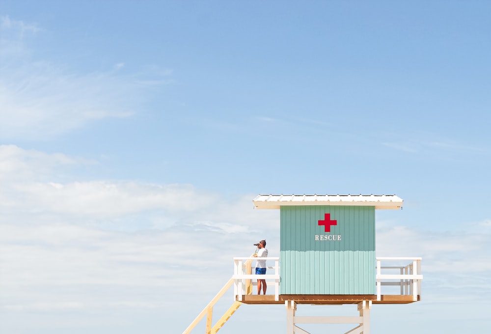 Weißes und rotes hölzernes Rettungsschwimmerhaus unter blauem Himmel tagsüber