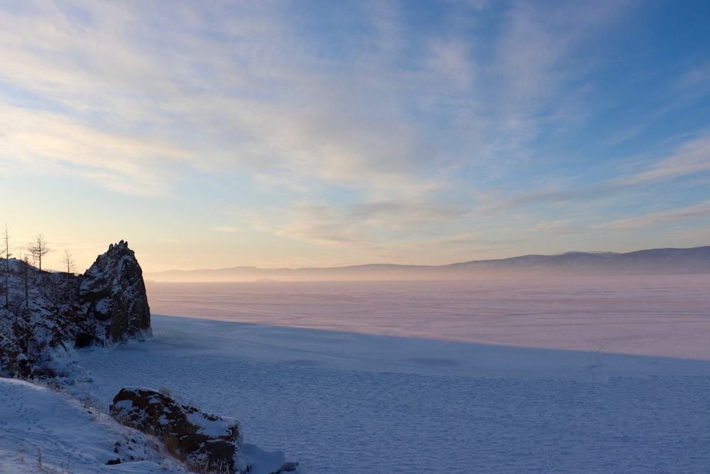 brown rock formation on sea under white clouds during daytime