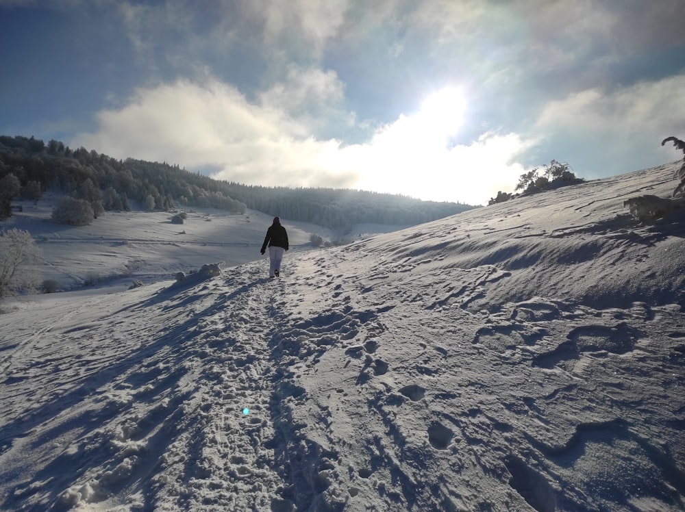 person walking on snow covered mountain during daytime