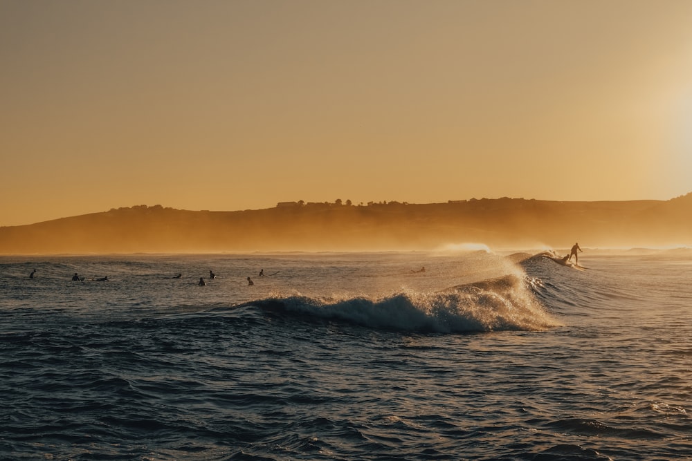 ocean waves crashing on shore during sunset