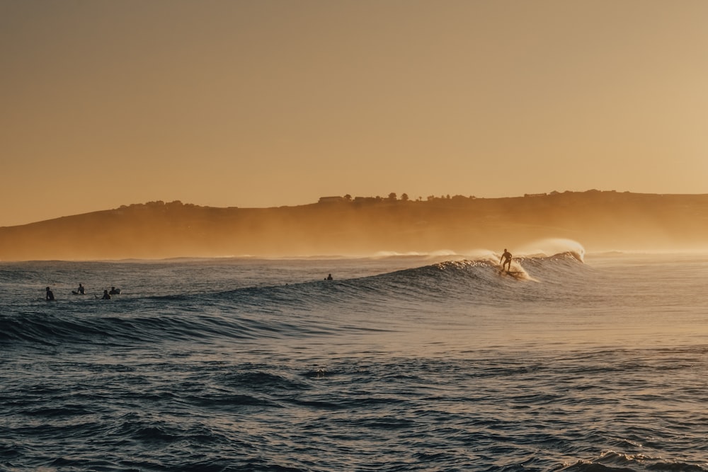 ocean waves under orange sky during sunset