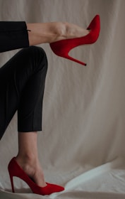 person in black pants and red shoes