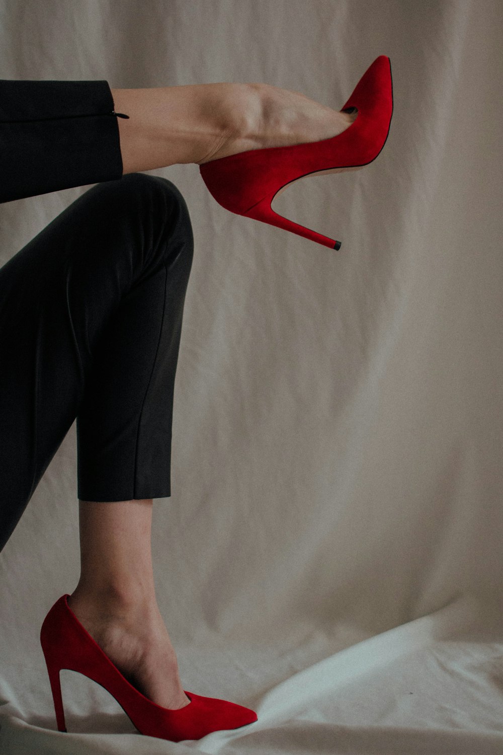 Persona con pantalones negros y zapatos rojos