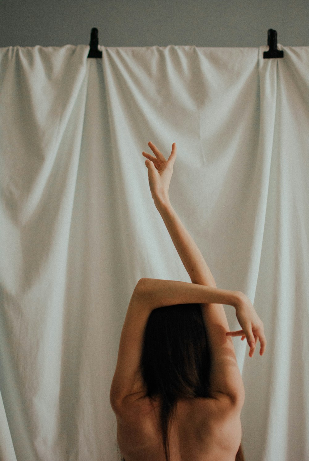 woman in black tank top raising her hands