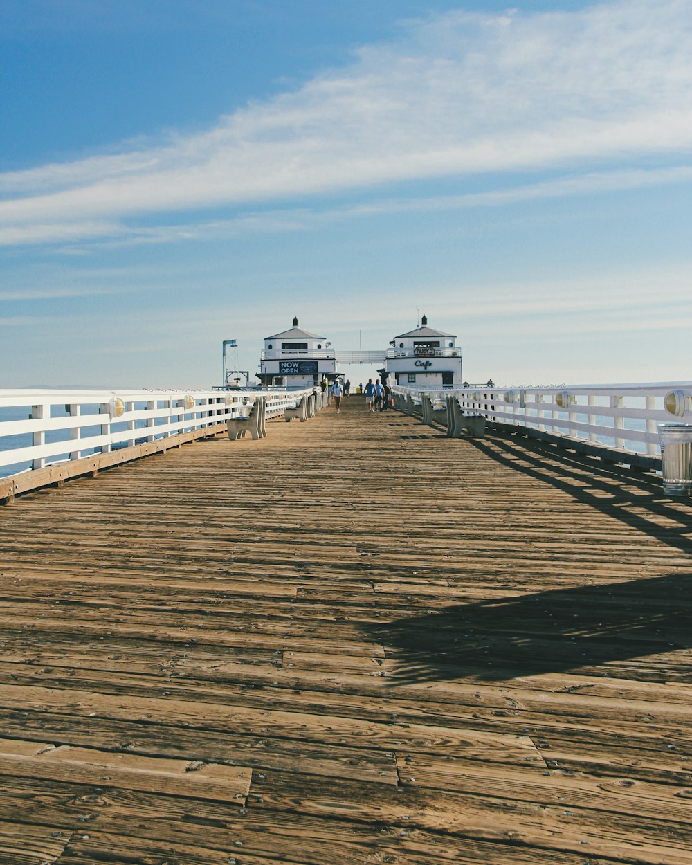 brown wooden dock on sea under blue sky during daytime