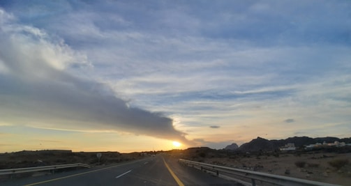 A scenic highway stretching from Casablanca towards the Atlas Mountains at sunset.