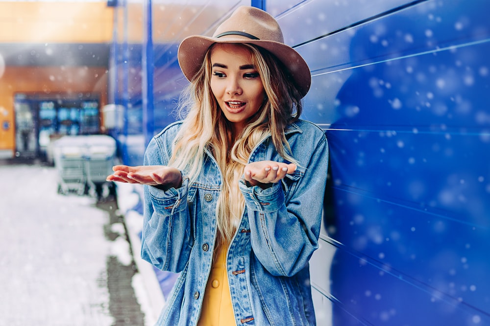 woman in blue denim jacket and brown fedora hat