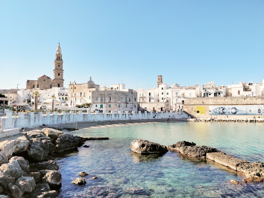 edificio in cemento bianco vicino a uno specchio d'acqua durante il giorno