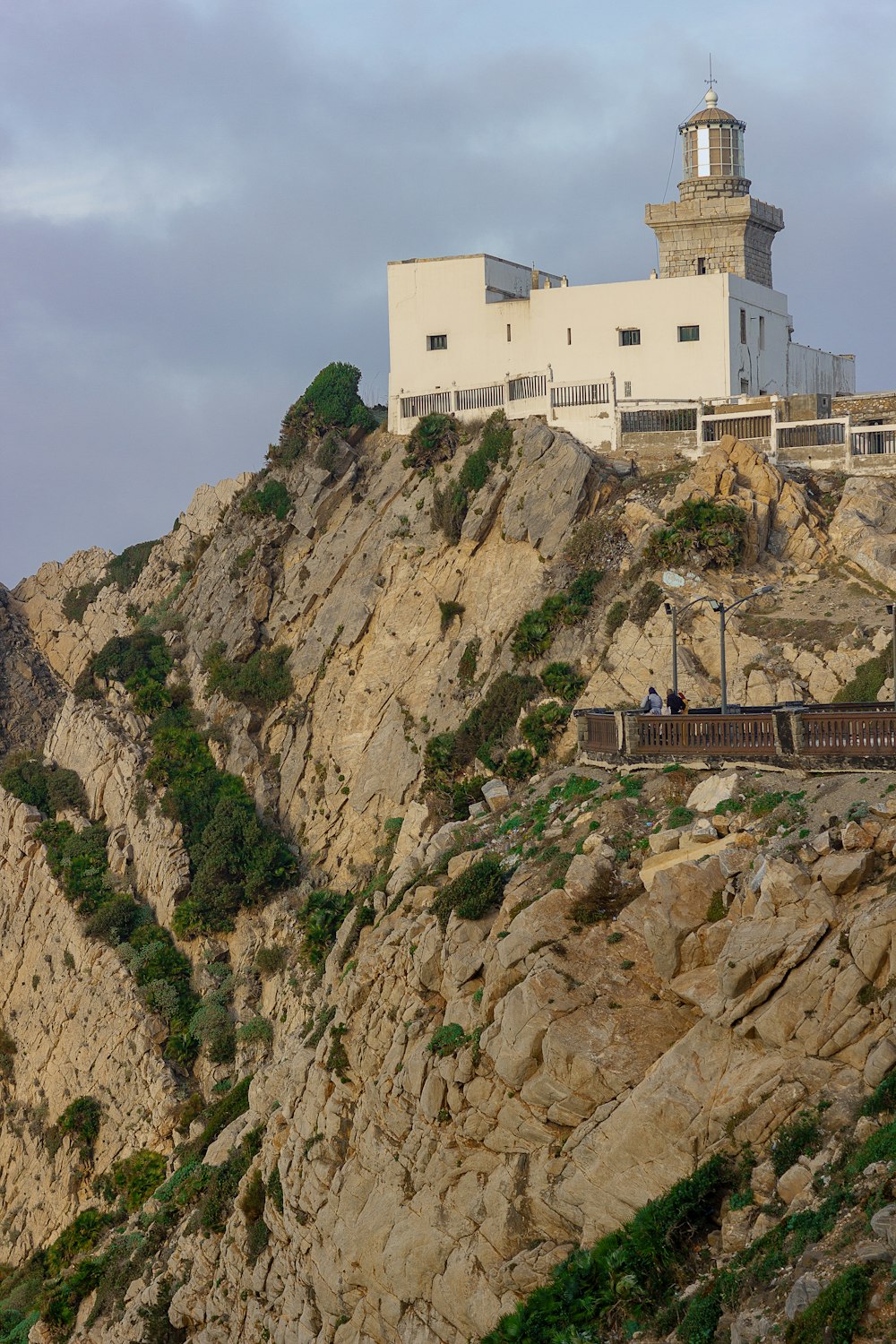 white concrete building on brown rocky mountain under blue sky during daytime