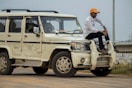 man in white long sleeve shirt and orange hat standing beside white jeep wrangler