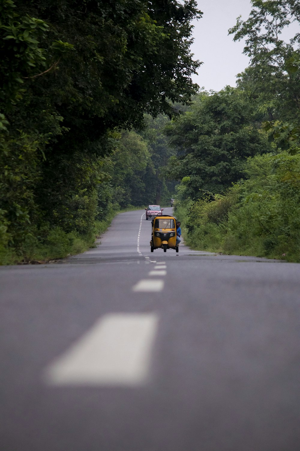 Rickshaw amarillo y negro en la carretera durante el día