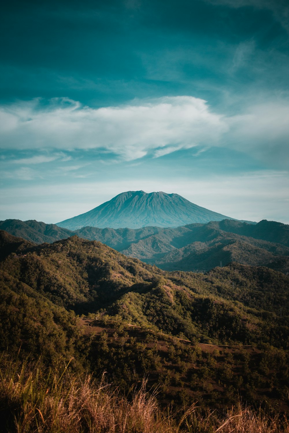 昼間の白い雲の下の茶色の山