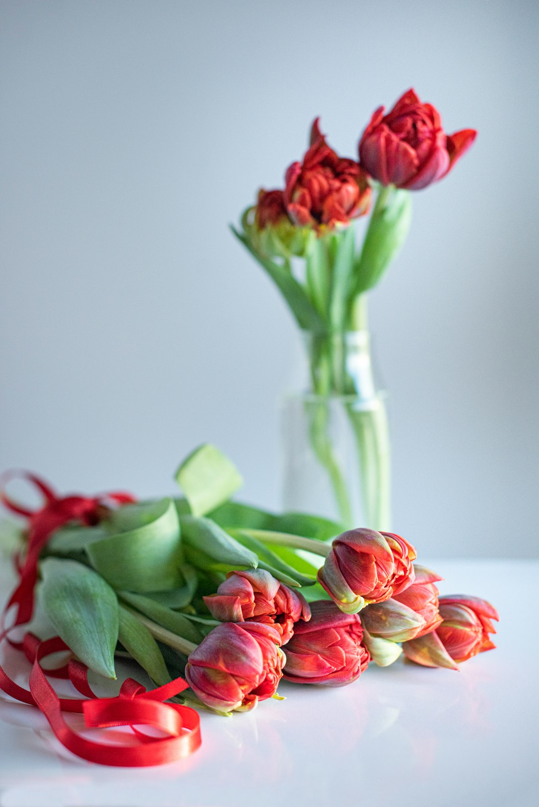 red and pink roses in clear glass vase