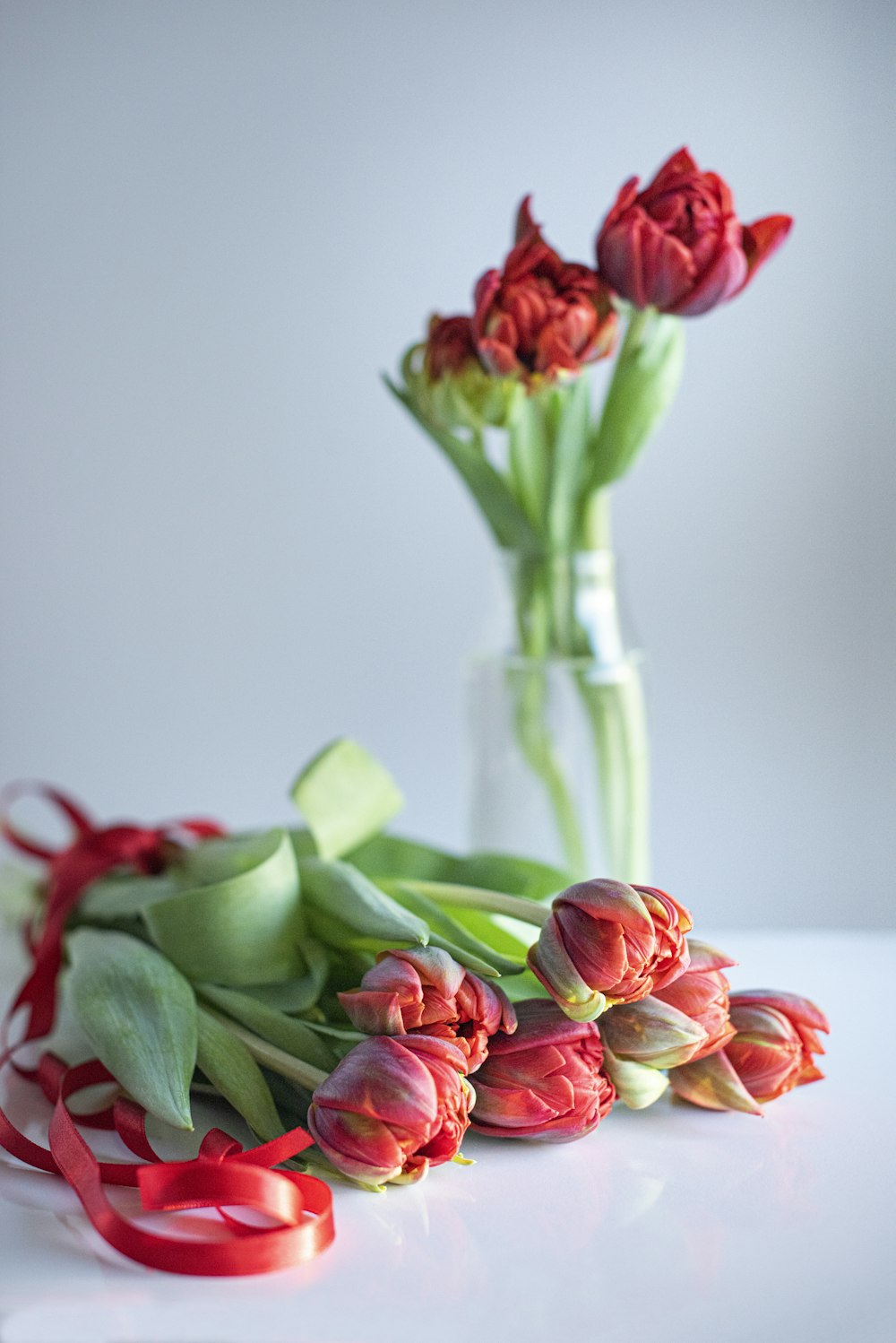 red and pink roses in clear glass vase