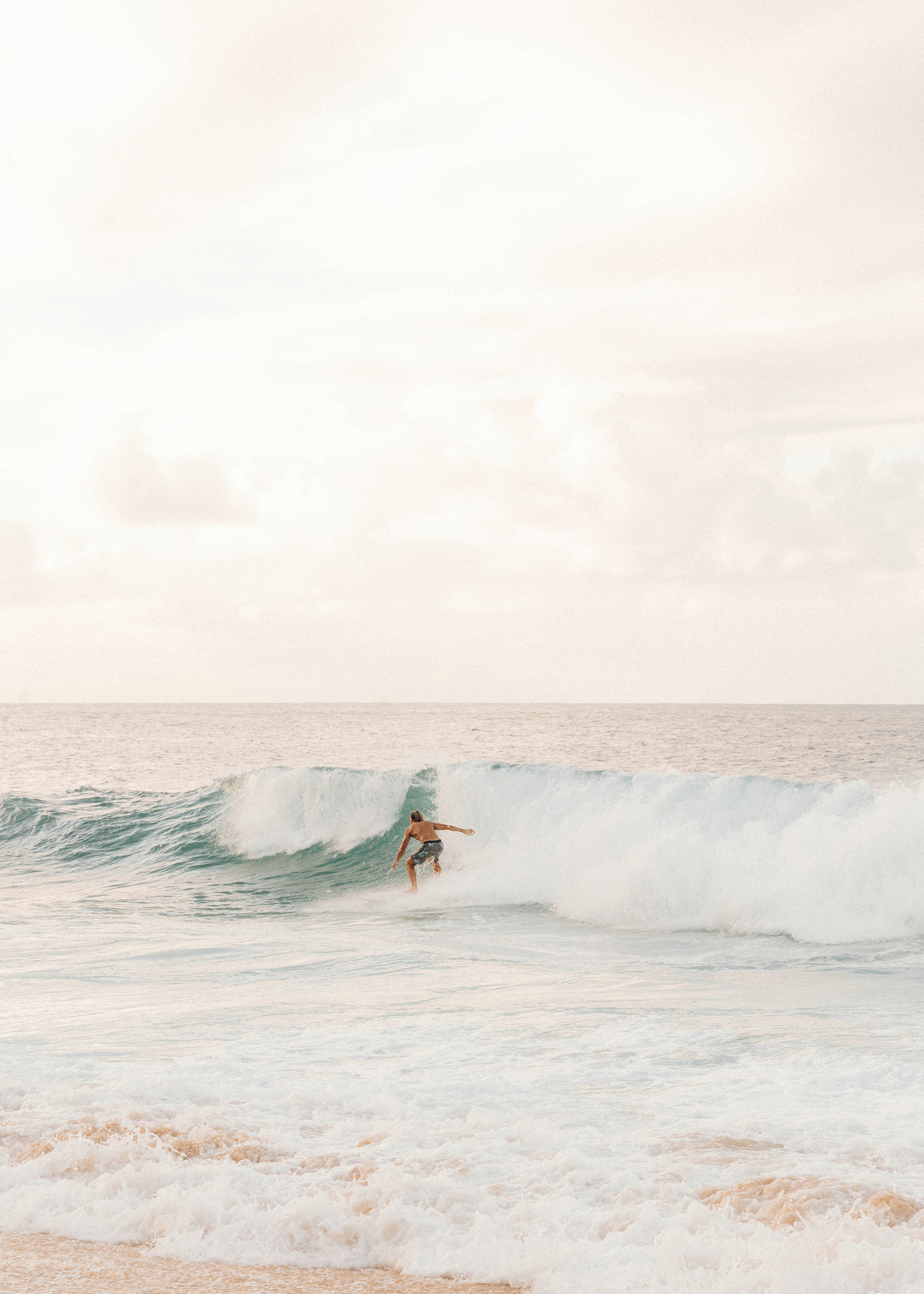 man surfing on sea waves during daytime