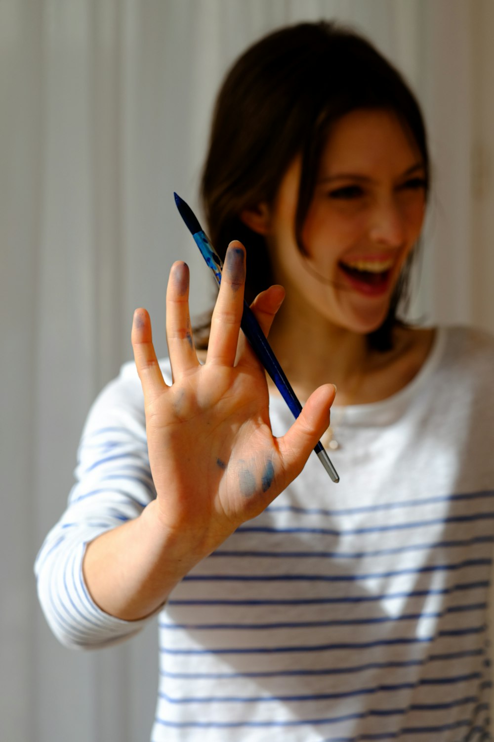 woman in white crew neck shirt holding blue pen