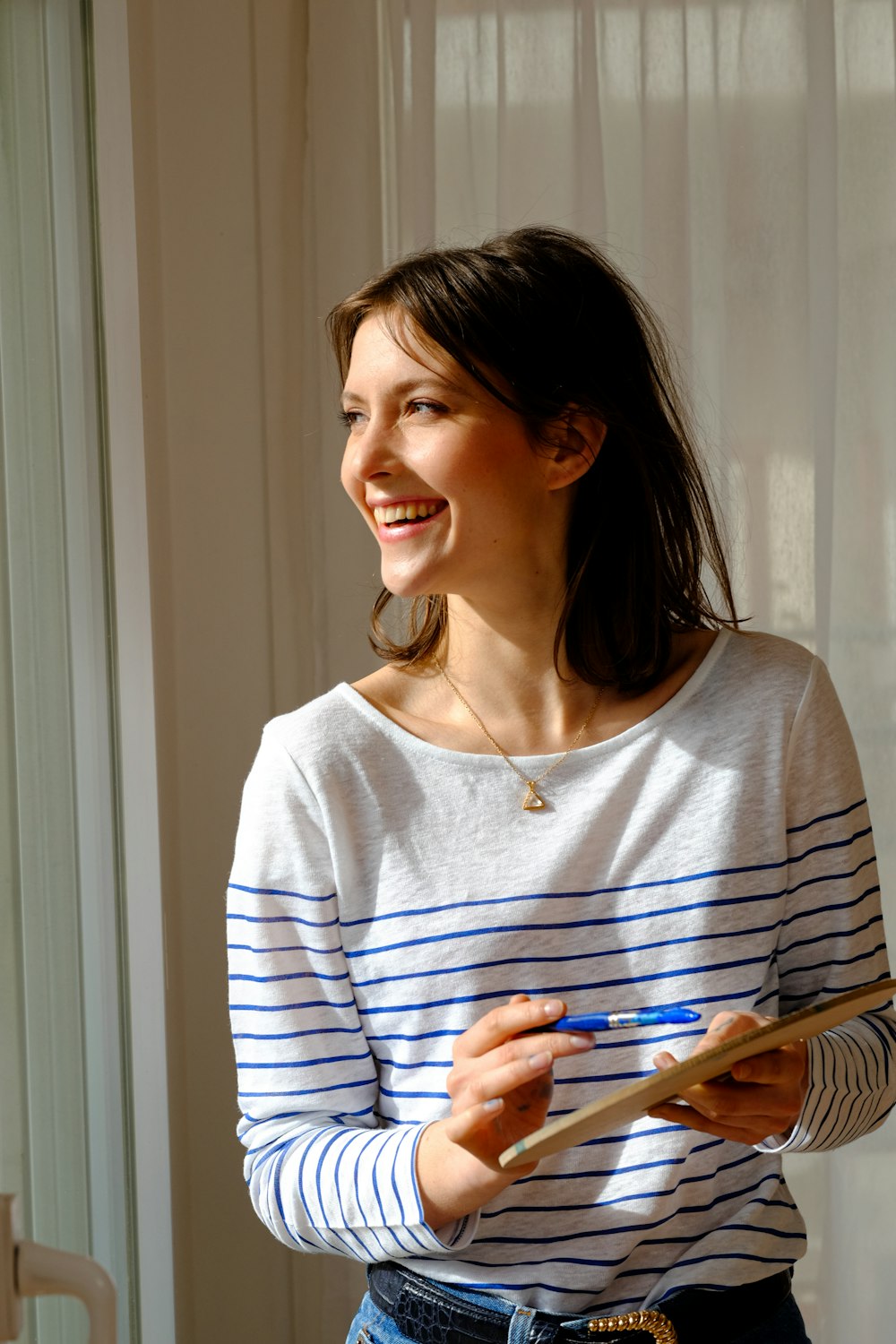 woman in gray and white striped long sleeve shirt smiling