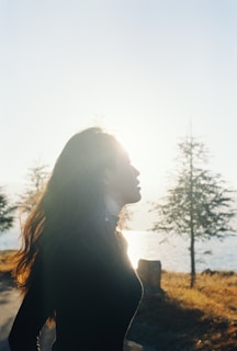 woman in black shirt standing near trees during daytime