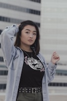 Model wearing a modern black tee with sharp white lines, standing casually outdoors.