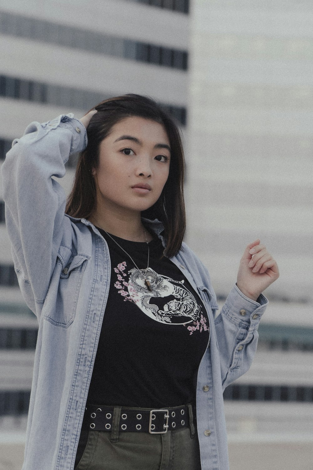 woman in black and white floral shirt and blue jacket