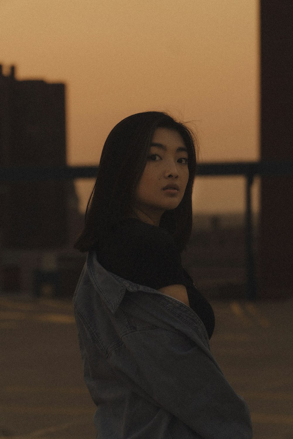 woman in gray scarf standing near yellow wall